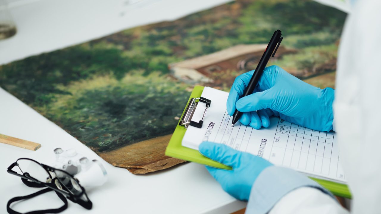 Professional oil painting condition assessment, creating a report. Conservator taking preliminary notes for their condition report on an oil painting